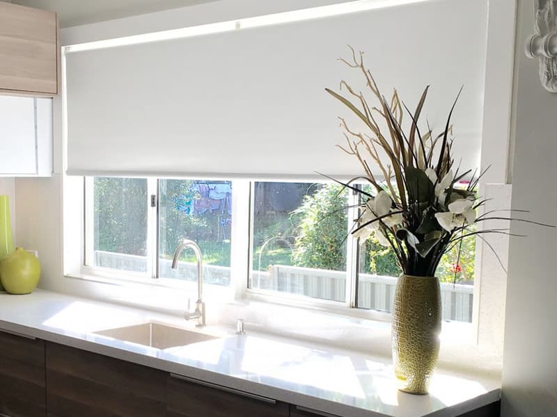 Modern Kitchen Roller Blinds Warrington | Made to Measure Blinds Light grey roller blind fitted above kitchen window in modern home in Warrington by Poppy Blinds